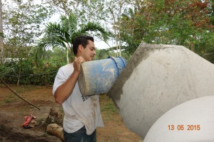 Erwin Lopez the Campus Minister loads the concrete mixer
