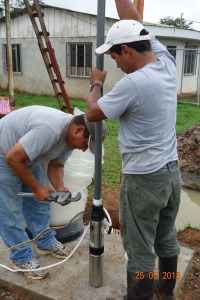 Chente and Frank  lowering the pump into the well. 
