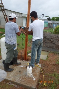 Chente and Omar lowering the pipe and pump assembly into the well. 