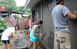 AVS interns help with applying concrete mortar.